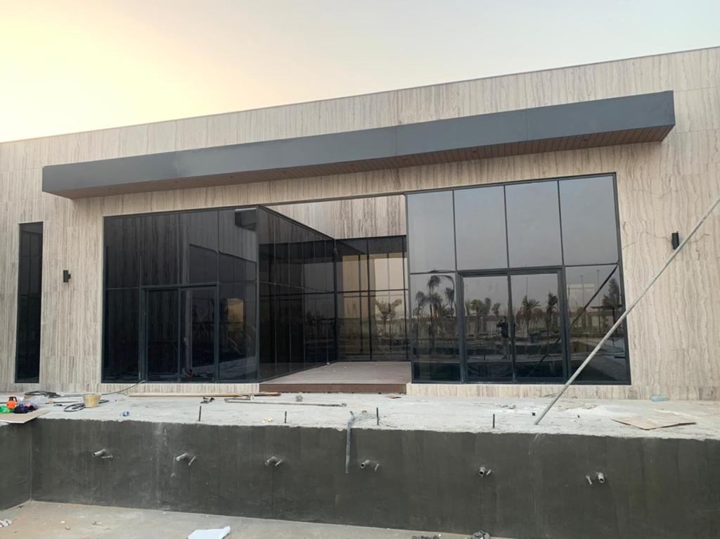 Glass wall across a villa wing beside the pool shell - Zealcon