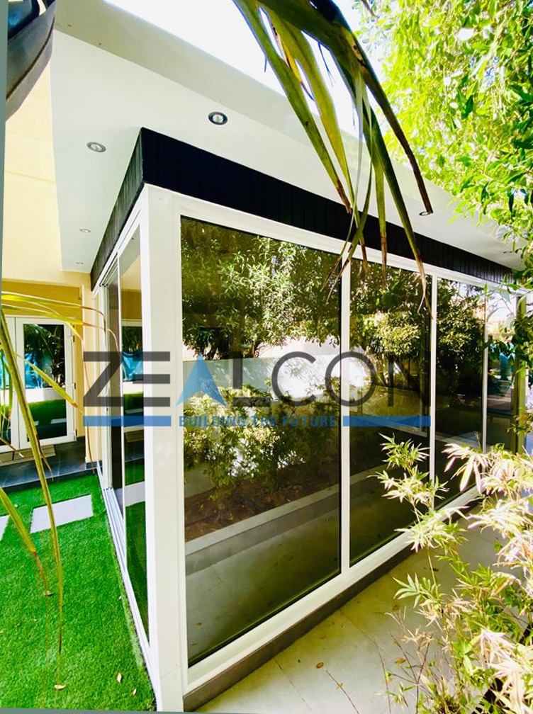 Sunrooms & Conservatories 6 Shaded glass lounge with frameless sliding glass - Zealcon