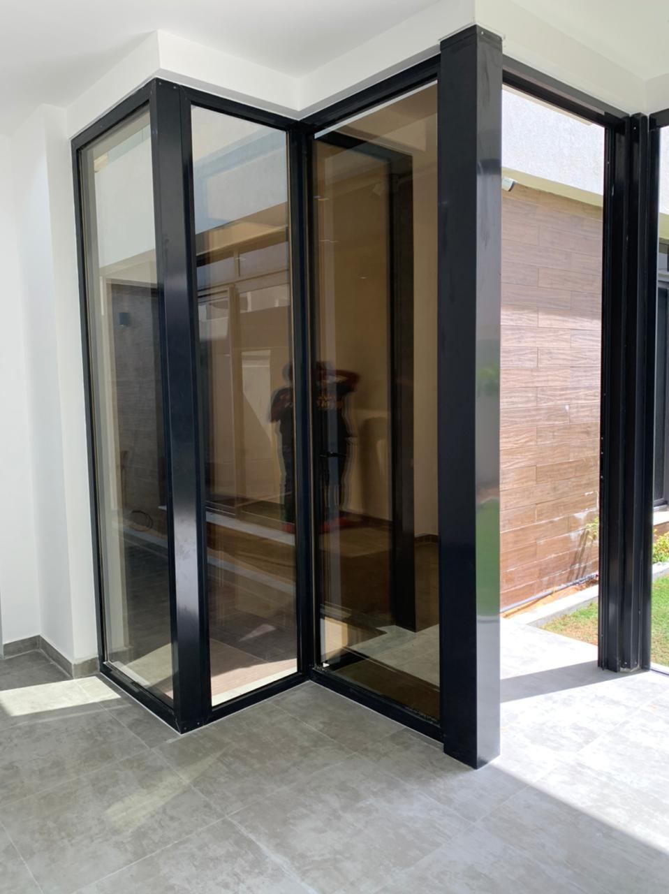 Frameless Folding Doors 8 Corner black framed glass doors with tinted glazing - Zealcon
