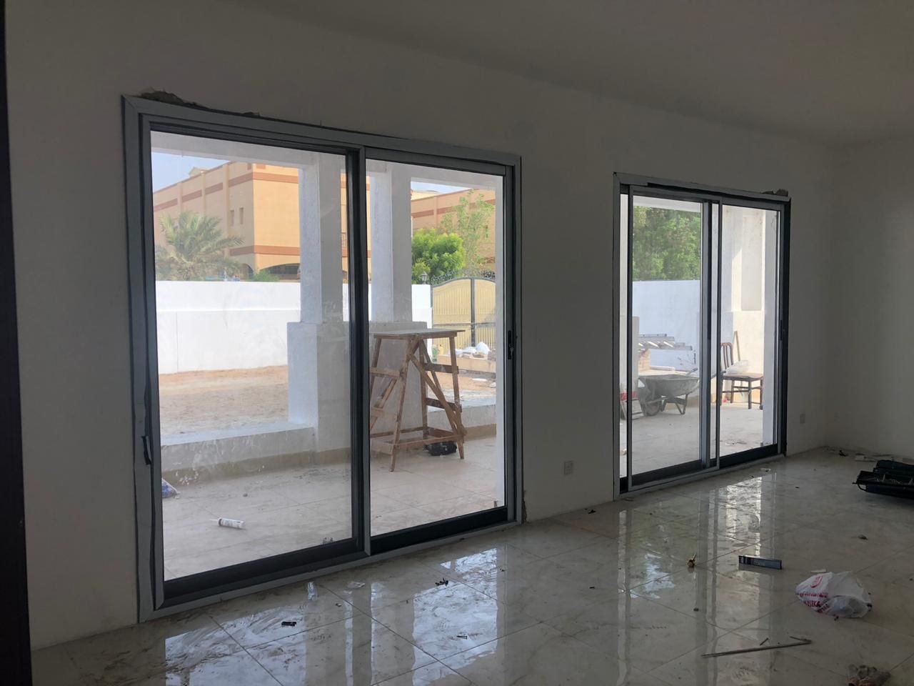 Floor-to-ceiling grey framed sliding doors in a villa room - Zealcon