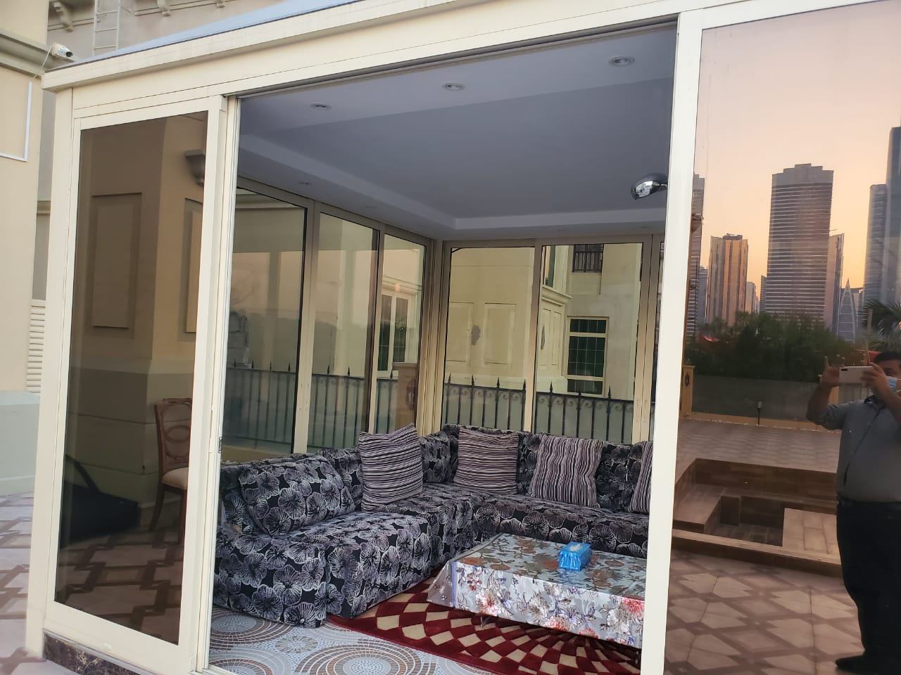 Glass Majlis 5 Wide open white framed sliding door into a sitting majlis - Zealcon